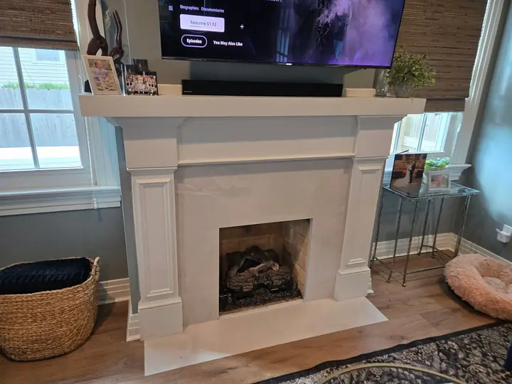 Painted wood fireplace mantel with fluted pilasters