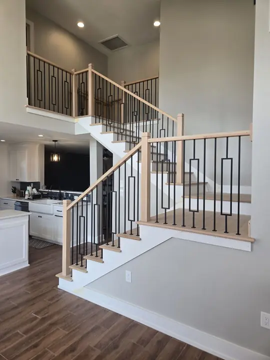 Open staircase with black iron balusters and white oak treads and rails
