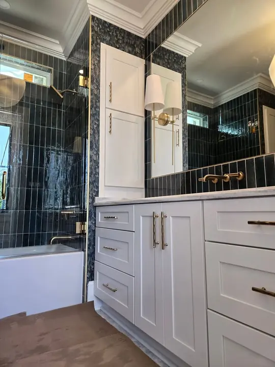 White bathroom vanity with linen storage tower and marble countertop