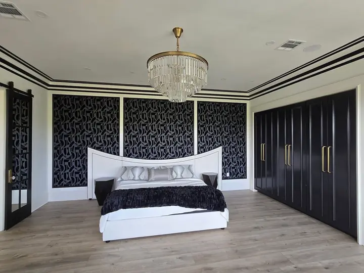 Black lacquer built-in wardrobe closet with brass hardware in a bedroom