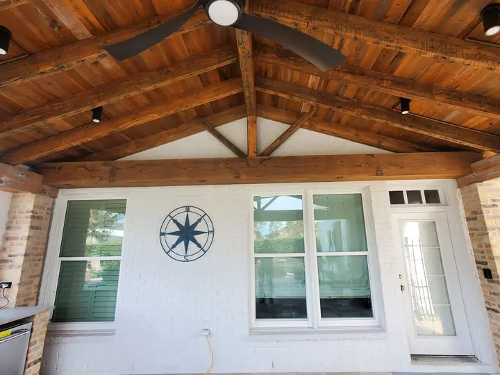 Covered porch with exposed wood beam ceiling and ceiling fan