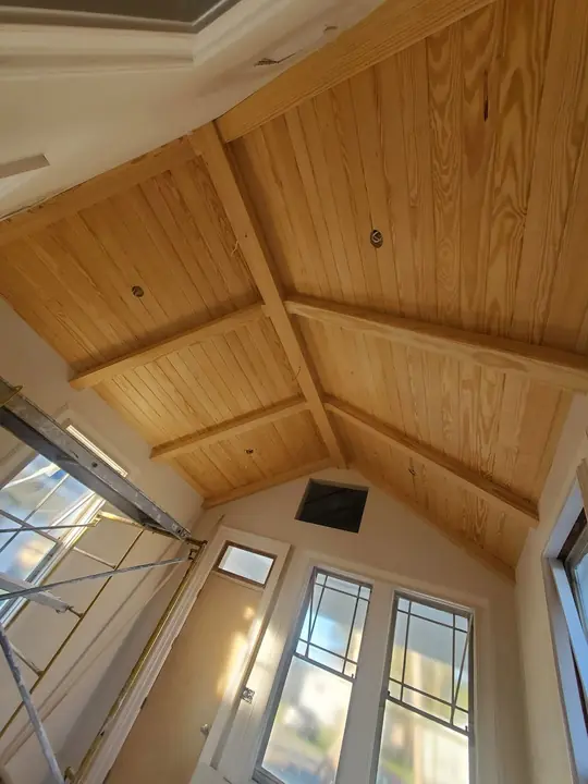 Vaulted ceiling with natural pine tongue-and-groove boards and exposed beams