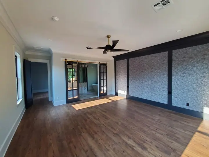 Room with dark trim wall paneling and a sliding barn door, pre-finish