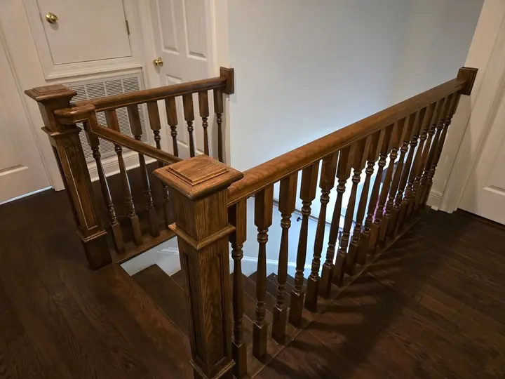 Close-up of hand-turned wood balusters and newel post on a staircase