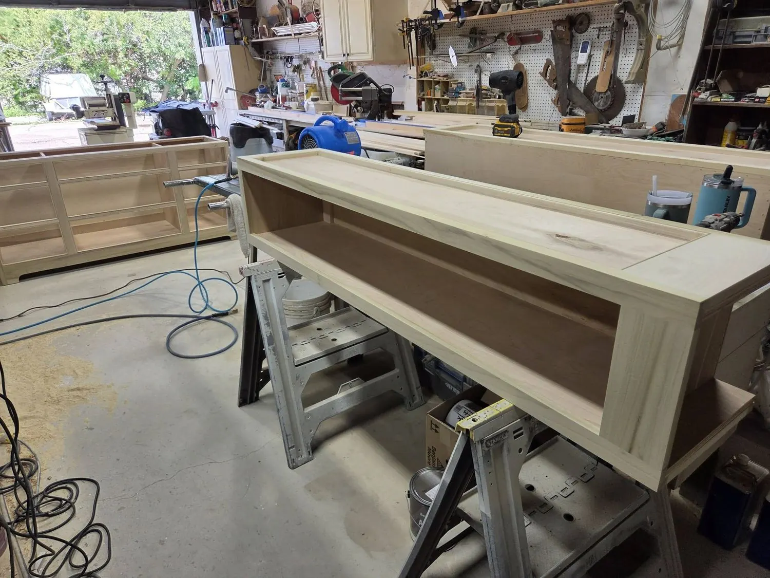 Raw wood cabinet carcasses lined up in the workshop, unfinished